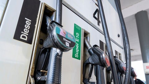 Zapfpistolen für Kraftstoff hängen an einer Tankstelle in der Halterung.