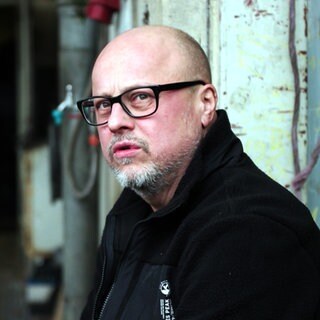 LKW-Fahrer Christian steht vor einer Ladehalle