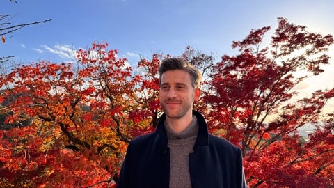 Dominik Zepp steht vor einem Baum 