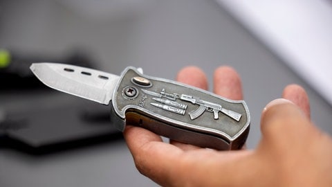 Ein Polizeibeamter hält ein sichergestelltes, verbotenes Springmesser in der Hand: Tödliche Messerangriffe nehmen zu und beschäftigen die Polizei nicht erst seit den Ereignissen von Solingen. Hier war das Motiv Terrorismus. Das ist aber die Ausnahme bei der Messergewalt. 