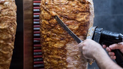 Dönerspieße drehen sich in einem Imbiss (Symbolbild)