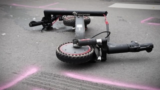 Ein E-Scooter liegt auf dem Boden. (Symbol) Im hessischen Rüdesheim ist ein Mann aus Mainz mit einem E-Scooter am Rheinufer abgestürzt und tödlich verunglückt (Symboldbild)