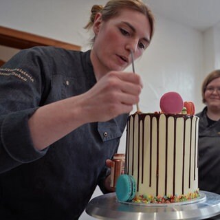 Konditorin Theresa Goka Dehen verpasst einer Torte den letzten Schliff