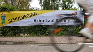Ein Banner mit der Aufschrift "Schulbeginn - Achtet auf Kinder!" ist bei polizeilichen Maßnahmen zum Schulbeginn zu sehen.