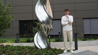 Tim Bengel vor seiner Skulptur am Landratsamt Esslingen