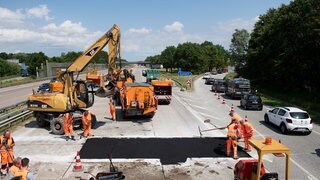 Die Hitze kann auf Straßen Spuren hinterlassen. Auf dem Bild werden Asphaltarbeiten durchgeführt. 