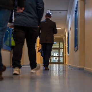 Geflüchtete auf einem Flur in der Erstaufnahmeeinrichtung in Trier. Viele Flüchtlinge haben Angst, abgeschoben zu werden.