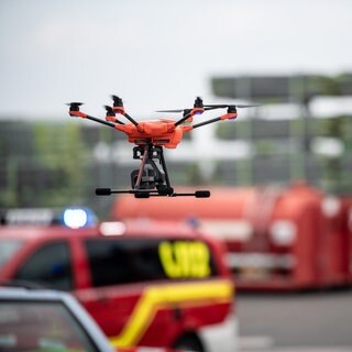 Eine Drohne fliegt vor Einsatzfahrzeugen bei einem Test-Einsatz. Das Deutsche Rettungsrobotik-Zentrum (DRZ) stellt einen neuartigen Robotikleitwagen für Katastropheneinsätze vor. 