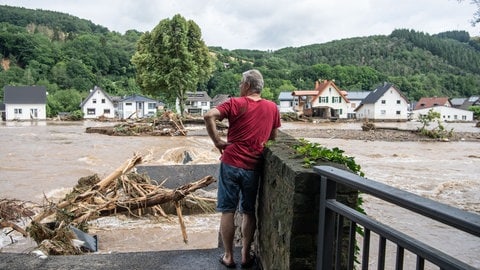 Ein Mann in Insul blickt zu seinem Elternhaus auf der anderen Flussseite hinüber.