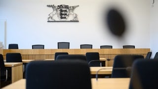 Das große Landeswappen von Baden-Württemberg hängt in einem Gerichtssaal im Gebäude des Oberlandesgerichts über den Richterstühlen. 