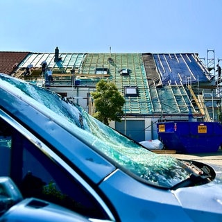 Die vom Tornado betroffenen Häuser in Ulm Gögglingen-Donaustetten sind noch mit Planen abgedeckt. Handwerker sind mit dem Wiederaufbau beschäftigt.