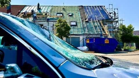 Die vom Tornado betroffenen Häuser in Ulm Gögglingen-Donaustetten sind noch mit Planen abgedeckt. Handwerker sind mit dem Wiederaufbau beschäftigt.