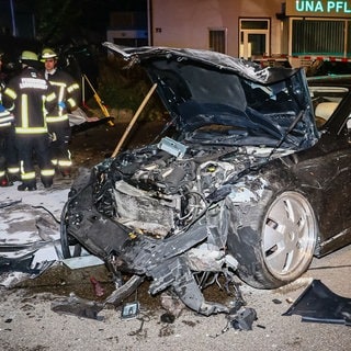 Rettungskräfte stehen an der Unfallstelle in Ludwigsburg neben dem Wrack einer der Limousine. Dieses war wohl wegen eines  illegalen Autorennens ins Fahrzeug zweier unbeteiligter Frauen gerast. Beide starben noch an der Unfallstelle.  
