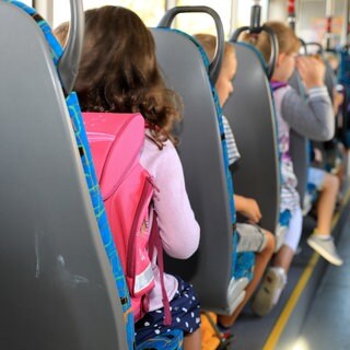 Kinder sitzen in einem Schulbus.