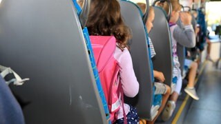 Kinder sitzen in einem Schulbus.