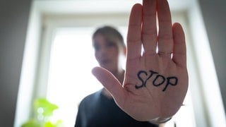 Eine Frau hält eine Hand auch auf der Stop steht. (Symbolbild) Die Frauennotrufe rund um Koblenz melden einen Anstieg bei Fällen von digitaler Gewalt gegen Frauen.