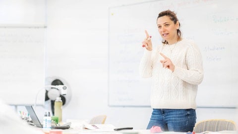 Weiterbildung: Nur die Hälfte der Beschäftigten in Deutschland plant eine Fortbildung im Beruf -so eine Studie der Bertellsmann Stieftung. Dozentin steht vorne in einem Unterrichtsraum und erklärt offenbar etwas.