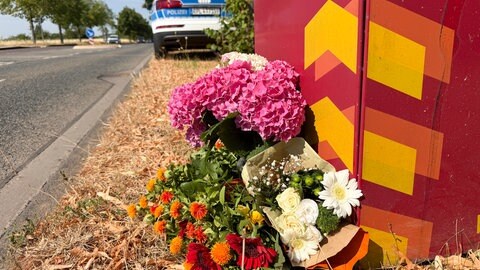 Blumen liegen an der Stelle, wo am Mittwoch ein Student bei einem Messerangriff auf offener Straße in Trier getötet worden ist.