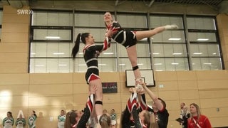 Cheerleader beim Üben in einer Halle