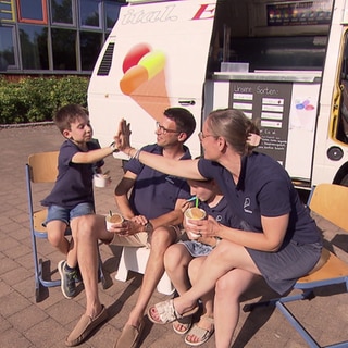 Familie isst Eis vor dem eigenen Eiswagen