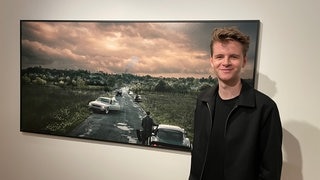 Der Mainzer Foto-Künstler Moritz Koch vor einem seiner Werke, die in der Sonderausstellung des Landesmuseums Mainz zu sehen sind.