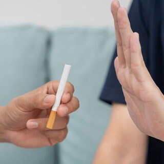 Ablehnende Handbewegung auf das Anbieten einer Zigarette