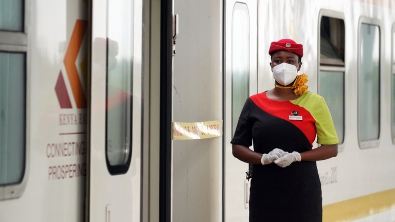 In Mombasa wartet eine elegante Bahnhostess auf Passagiere.