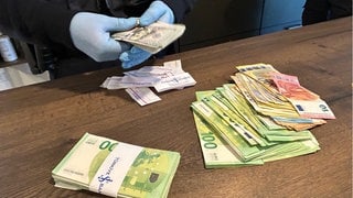 Auf einem Tisch präsentieren Zollbeamte den Bargeld-Fund nach einer Durchsuchung in Tübingen: Bei einem Bauunternehmen besteht Verdacht auf Schwarzarbeit.