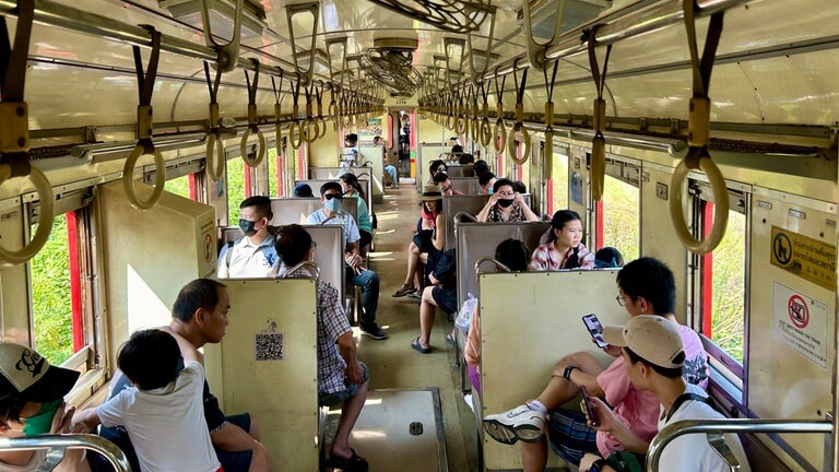 Es sind nicht nur die ausländischen Marktbesucher, die mitfahren. Zugfahren ist billig in Thailand, und so nutzen die Einheimischen die Bahn gerne. 