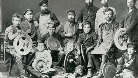 Schwarz-weiß-Aufnahme mit Pfaff-Mitarbeitern im Jahr 1868. Viele Männer mit Bärten und Kinder, sie halten Spulen mit Nähgarn.