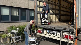 Zwei Männer beladen einen Lkw mit Hilfsgütern für die Ukraine.