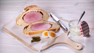 Kassler im Teigmaltel liegt aufgeschnitten und angerichtet auf einem Schneidebrett: Nach dem Rezept von SWR4 Konditor Joachim Habiger lässt sich Braten herzhaft und raffiniert unter Brotkruste verstecken.