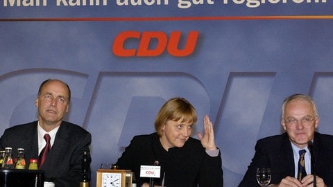 Die Bundesvorsitzende der CDU, Angela Merkel, sitzt am 11.1.2002 während einer zweitägigen Klausur-Tagung ihrer Partei in Magdeburg zwischen CDU-Generalsekretär Lorenz Meyer (links) und dem Vorsitzenden der nordrhein-westfälischen CDU, Jürgen Rüttgers.