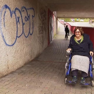 Eine Frau im Rollstuhl durchfährt eine Unterführung