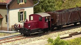 Spielzeugeisenbahn hält am Bahnhof