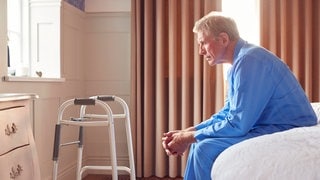 Ein Mann sitzt auf seinem Krankenhausbett. In RLP gibt es mehr Fälle von Demenz, die Kliniken sind laut Barmer nicht ausreichend vorbereitet. (Symbolbild)