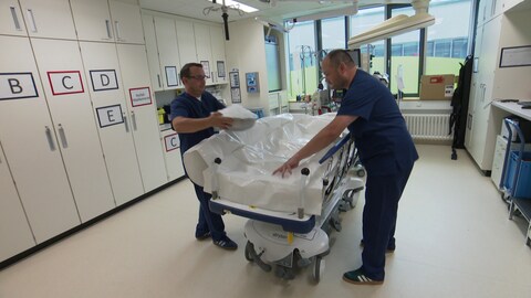 Ein Arzt der Notaufnahme befüllt einen Body Bag mit Eis um später einen Patienten zu kühlen.