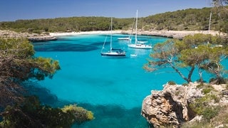 Segelyachten ankern in der Bucht s'Amarador, Cala Mondragó, Naturschutzgebiet Parc Natural de Mondragó, Mallorca.