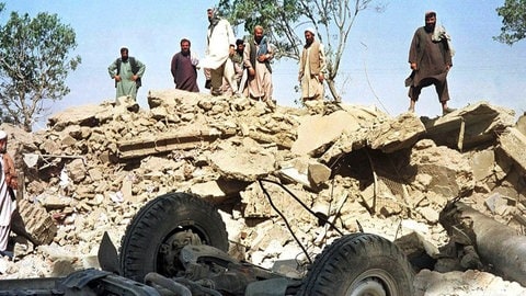 Afghanen blicken am 9.10.2001 auf die Trümmer des Gebäudes der von den Vereinten Nationen (UN) finanzierten Minenräumorganisation Afghan Technical Consultants in Kabul.