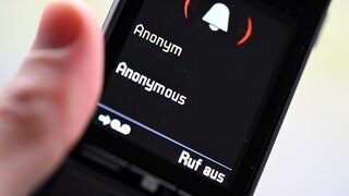 Jemand hält ein Telefon, auf dem ein anonymer Anruf eingeht. (Symbolbild)