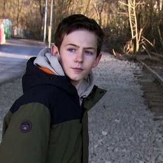 Christian aus Kirchheim will die stillgelegte Bahnstrecke reaktivieren. Er trägt eine WInterjacke und steht neben den Bahngleisen.