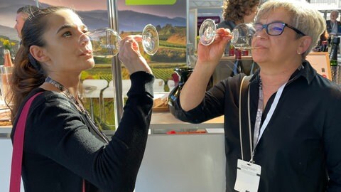 Zwei Frauen trinken auf der Eurovino in Karlsruhe Wein. Auf der Fachmesse hat BW-Minister Hauk (CDU) neue Konzepte für Winzer vorgestellt.