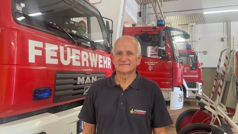 Andreas Häcker von der Feuerwehr Ditzingen steht vor den Einsatzfahrzeugen.