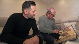 Mario Reale und sein Sohn schauen sich alte Fotos an 