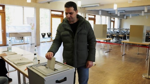 Ein Mann wirft einen Wahlzettel in eine Wahlurne: Mostafa Elyasian gibt in einem Tübinger Wahllokal zum ersten Mal bei einer Bundestagswahl seine Stimme ab. 