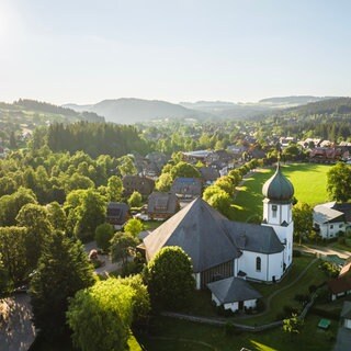Wandern im Schwarzwald: Blick auf den Ort Hinterzarten und das Bergpanorama im Hintergrund