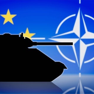 Silhouette eines Panzers vor den Flaggen der EU und der NATO: Am 4. April 1949 legten zwölf Staaten per Bündnisvertrag den Grundstein für die NATO – heute der größte und mächtigste Militärblock der Menschheitsgeschichte. Seit Russlands Angriffskrieg auf die Ukraine ist die Mission Bündnisverteidigung aktueller denn je. 