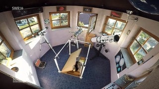 Eine Astronomiekuppel mit vielen Fenstern und mehreren Teleskopen