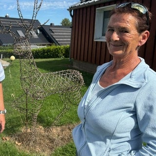 Manfred Bauer 8l.) und Andrea Thome rahmen die Statue von Hirsch Henry ein
