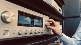Eine Hand dreht an einem Radioregler
